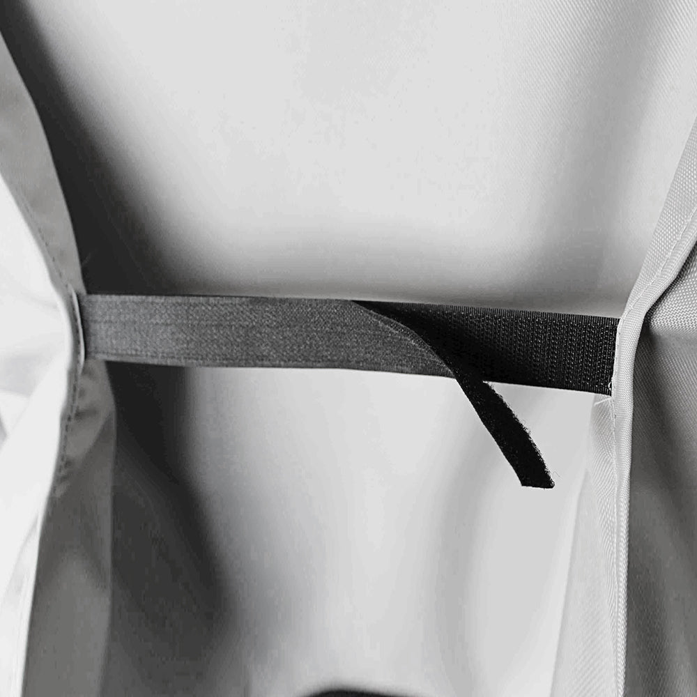 Close-up of a dark gray adjustable strap or band secured across a light gray fabric surface.