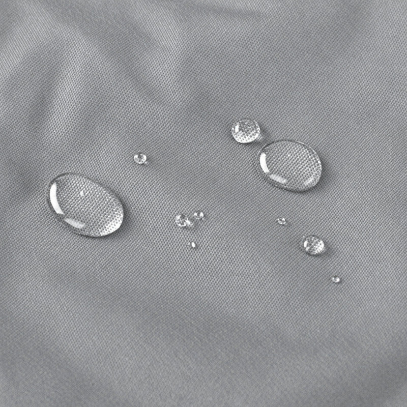 Close-up of a light gray textured fabric surface with several clear water droplets showing water repellency.